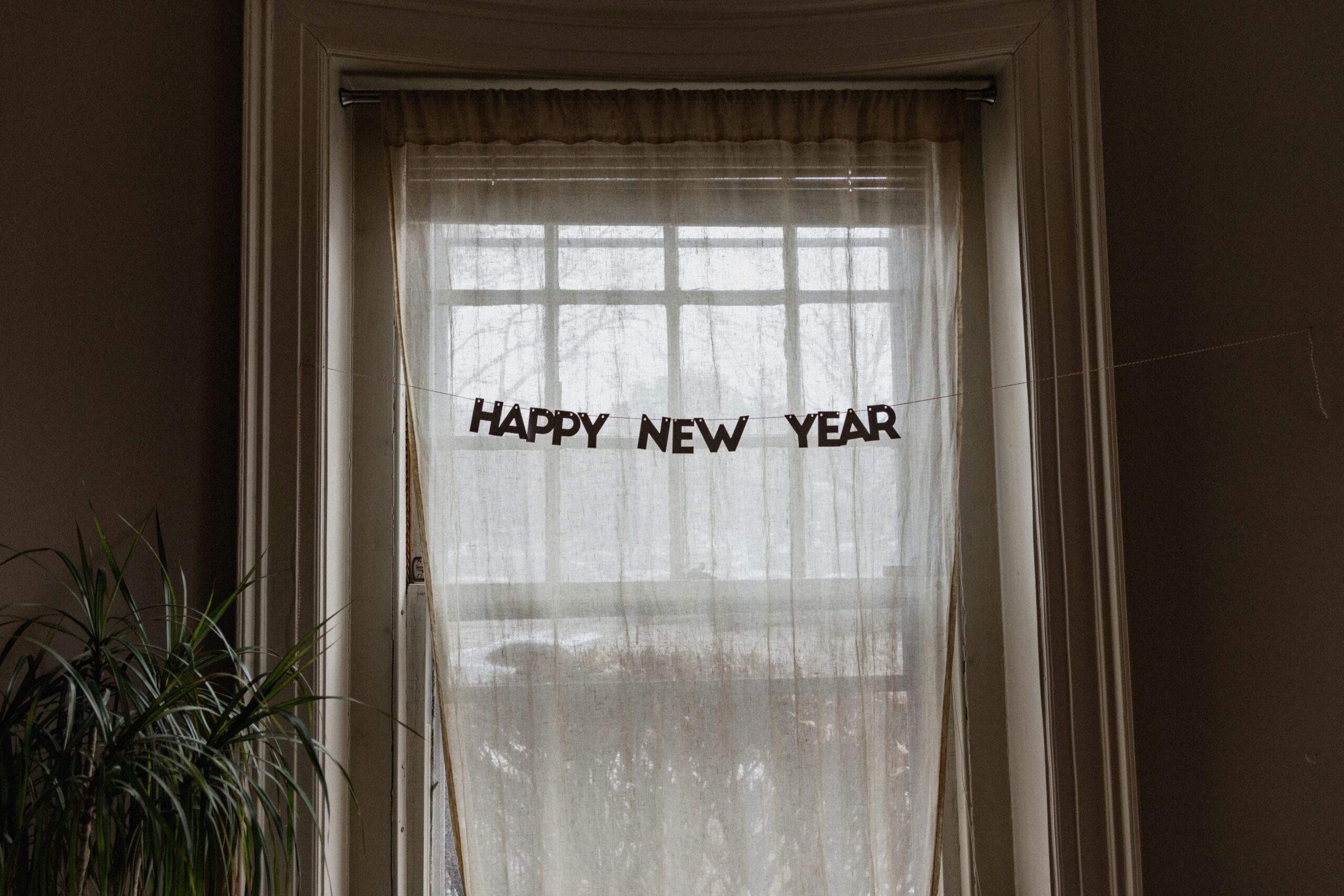 A decoration reading "Happy New Year" strung across a window.